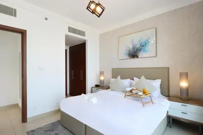 a bedroom with a large white bed with a table on it at Spacious 1BR with Open Views Boulevard Point Near Dubai Mall in Dubai