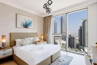 a bedroom with a large bed and a large window at Spacious 1BR with Open Views Boulevard Point Near Dubai Mall in Dubai