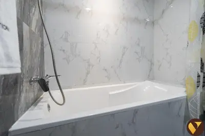 a white bath tub with a phone in a bathroom at Vogue Elite Business Bay Residence Close to Burj Khalifa and Dubai Mall, Studio Apartment with Balcony, City and Canal View, Access to all Amenities in Dubai