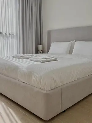 a large white bed with white sheets and pillows at Luxury 1BR Retreat with Dubai Marina views by Crescent Key in Dubai