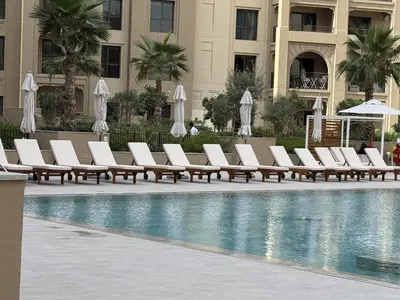 a row of lounge chairs next to a swimming pool at Luxury 1BR Retreat with Dubai Marina views by Crescent Key in Dubai