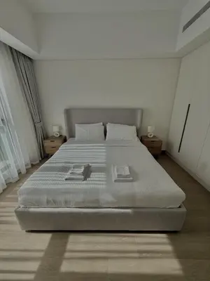 a white bedroom with a large bed in a room at Elegant 1BR with Skyline View Bright & Modern by Crescent Key in Dubai