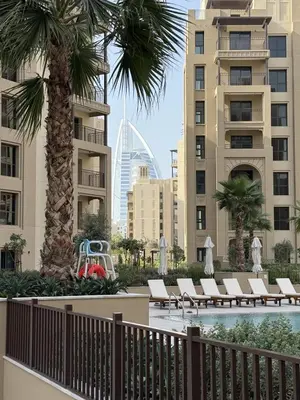 a resort with a pool and palm trees and buildings at Elegant 1BR with Skyline View Bright & Modern by Crescent Key in Dubai