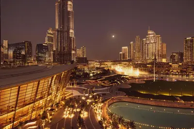 a view of a city at night with buildings at INCREDIBLE BURJ KHALIFA & DUBAI FOUNTAIN Views - 2 BR Luxury Apartment - Sanctuary Stays in Dubai