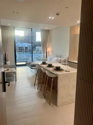 a kitchen and living room with a table and a couch at Elegant Dubai Stay Pool, Gym, Padel & Concierge in Dubai