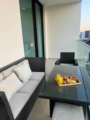a living room with a couch and a table with a tray of fruit at Elegant Dubai Stay Pool, Gym, Padel & Concierge in Dubai