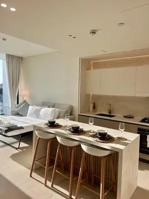 a kitchen and living room with a table and chairs at Elegant Dubai Stay Pool, Gym, Padel & Concierge in Dubai