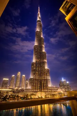 a tall building with a city skyline at night at Luxury Apartment in Burj Vista with Burj Khalifa View in Dubai