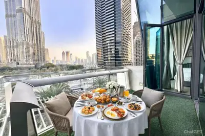 a table with plates of food on a balcony at Luxury Apartment in Burj Vista with Burj Khalifa View in Dubai
