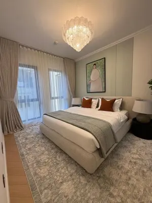 a bedroom with a large bed and a chandelier at Yansoon 4 , Old Town Downtown in Dubai