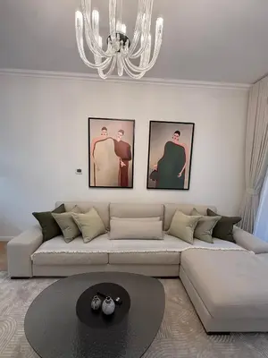 a living room with a large couch and three pictures on the wall at Yansoon 4 , Old Town Downtown in Dubai