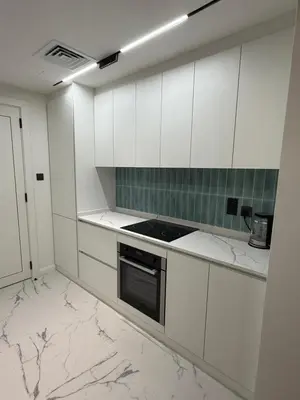 a kitchen with white cabinets and marble counter tops at Yansoon 4 , Old Town Downtown in Dubai