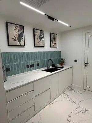 a kitchen with white cabinets and a sink at Yansoon 4 , Old Town Downtown in Dubai