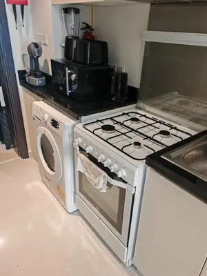 a kitchen with a stove and a washing machine at Modern Luxurious Studio Golf View Damac Community in Dubai