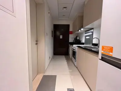 a kitchen with white cabinets and a black door at Modern Luxurious Studio Golf View Damac Community in Dubai