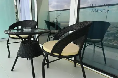 a group of chairs and a table in front of a window at Modern Luxurious Studio Golf View Damac Community in Dubai
