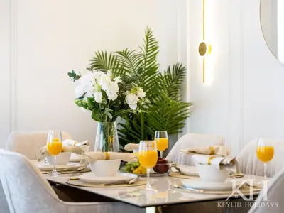 a dining room table with a vase of flowers and orange juice at keylid-Stunning-Luxury 2BR connected to Dubai Mall in Dubai