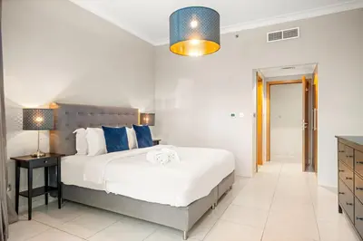 a bedroom with a large bed with blue pillows at FIRST CLASS 2BR Spectacular Marina Views in Dubai