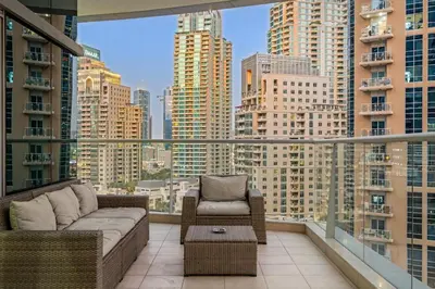 a balcony with a couch and chair on a city skyline at FIRST CLASS 2BR Spectacular Marina Views in Dubai