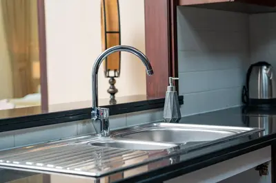 a stainless steel sink in a kitchen with a mirror at Burj Khalifa View 29 Boulevard Downtown - Free Parking in Dubai