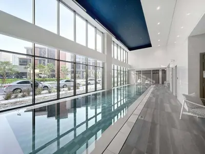 a large swimming pool in a building with glass windows at LUX 2 BDR apartment - Burj Khalifa view in Dubai