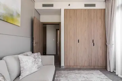 a living room with a couch and a wooden door at LUX 2 BDR apartment - Burj Khalifa view in Dubai