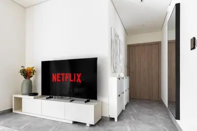 a television on a white entertainment center in a living room at LUX 2 BDR apartment - Burj Khalifa view in Dubai