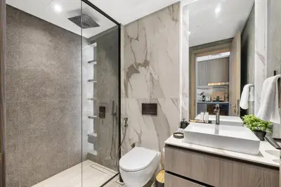 a bathroom with a toilet and a sink and a shower at Chic Studio with Balcony & Pool in Oxford Gardens in Dubai