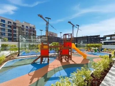 a playground with a slide in a building at Chic Studio with Balcony & Pool in Oxford Gardens in Dubai