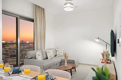 a living room with a couch and a table with wine glasses at FIRST CLASS 1BR Urban Serenity Near Downtown in Dubai