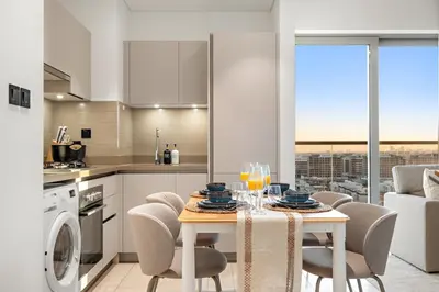 a kitchen with a table with chairs and a dining room at FIRST CLASS 1BR Urban Serenity Near Downtown in Dubai