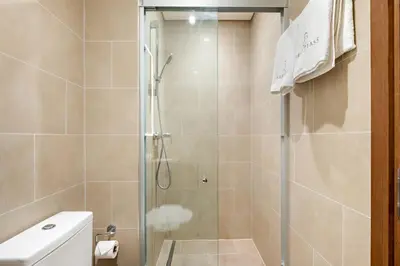 a shower with a glass door in a bathroom at FIRST CLASS 1BR Urban Serenity Near Downtown in Dubai