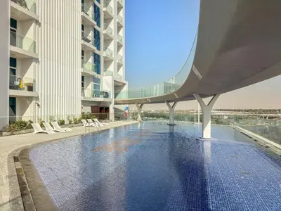 a swimming pool in the middle of a building at FIRST CLASS 1BR Miracle Garden View Skyz Arjan in Dubai