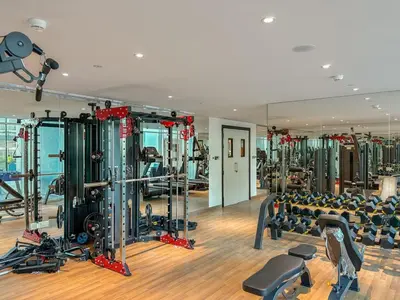 a gym with a lot of treadmills and machines at FIRST CLASS 1BR Miracle Garden View Skyz Arjan in Dubai