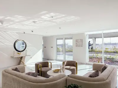 a living room with two chairs and a table at FIRST CLASS 1BR Miracle Garden View Skyz Arjan in Dubai