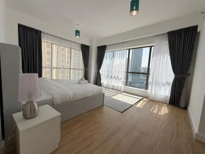 a bedroom with a large bed and large windows at 2BR Apartment in JBR The Walk in Dubai