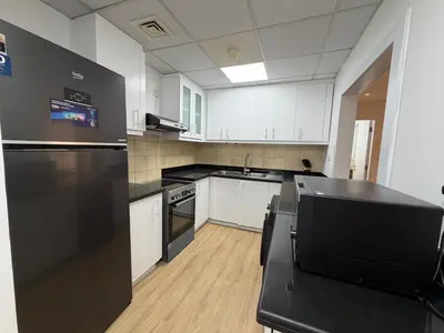 a kitchen with white cabinets and a black counter top at 2BR Apartment in JBR The Walk in Dubai