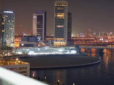 a city skyline at night with a body of water at Business Bay Luxury Apt - 5min Burj Khalifa, Mall & Metro in Dubai