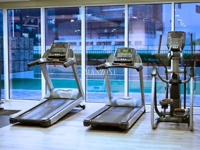 two exercise bikes in a gym with a window at Business Bay Luxury Apt - 5min Burj Khalifa, Mall & Metro in Dubai