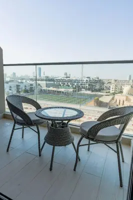 two chairs and a table on a balcony with a view at Nasma Luxury Stays - Contemporary Calm Living Space with upscale Facilities in Dubai