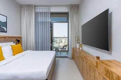 a bedroom with a large bed and a flat screen tv at Nasma Luxury Stays - Contemporary Calm Living Space with upscale Facilities in Dubai