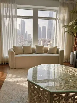 a living room with a couch and a glass table at Premium Downtown 1BD Apartment Burj Khalifa View 9 Mins walk Dubai Mall in Dubai