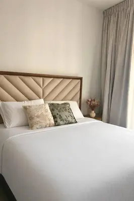 a white bed with two pillows on top of it at Premium Downtown 1BD Apartment Burj Khalifa View 9 Mins walk Dubai Mall in Dubai