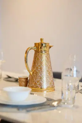 a gold tea kettle sitting on a table with plates at Luxury 3BR Burj View in Downtown Dubai in Dubai