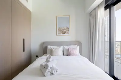 a bedroom with a white bed with towels on it at Luxury 3BR Burj View in Downtown Dubai in Dubai