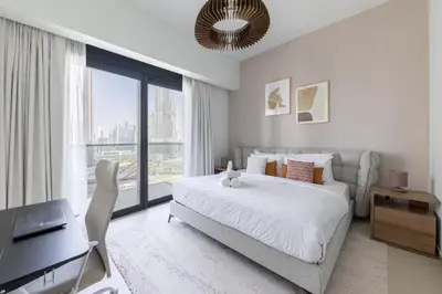 a bedroom with a large white bed and a desk at Luxury 3BR Burj View in Downtown Dubai in Dubai