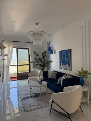 a living room with a blue couch and chairs at Sea View Spacious Apartment in JBR in Dubai