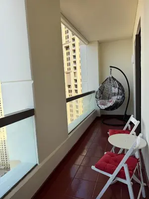 a room with a balcony with a table and a chair at Sea View Spacious Apartment in JBR in Dubai