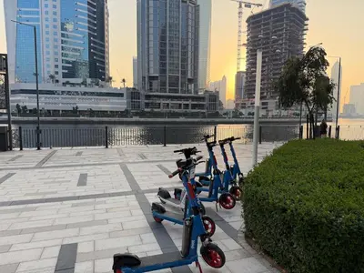 a row of scooters parked on a sidewalk in a city at Studio with Pool & Canal Views - Near Dubai Mall - Downtown in Dubai