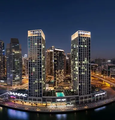 a city skyline with tall buildings at night at Studio with Pool & Canal Views - Near Dubai Mall - Downtown in Dubai